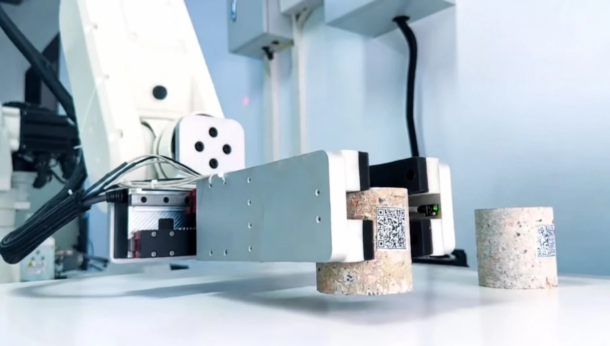 Concrete cube positioned inside a compression testing machine