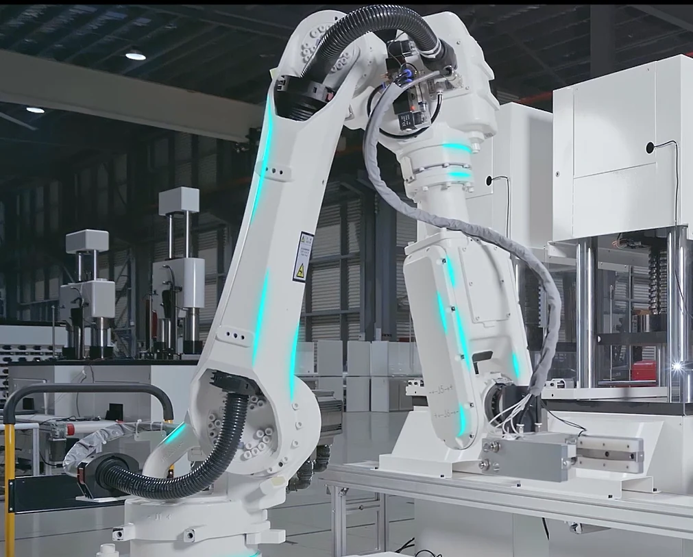 Robot positioned beside concrete compression testing equipment