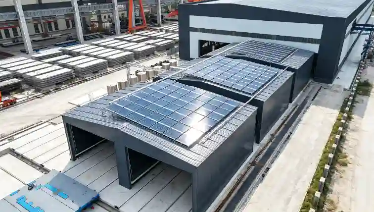 Enclosed precast concrete curing chambers with rooftop solar panels and rail tracks