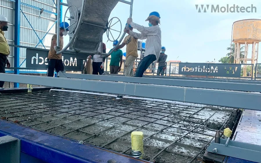 Worker placing concrete into a reinforced PPVC box mould