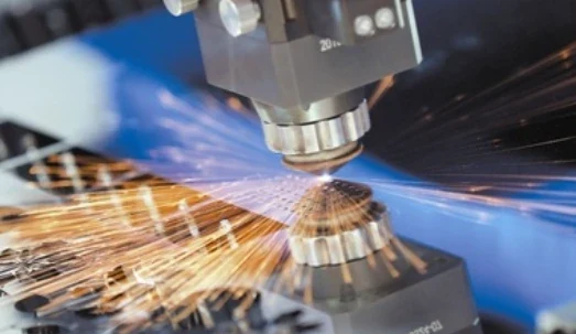 Laser cutting head working on sheet metal with visible cutting sparks